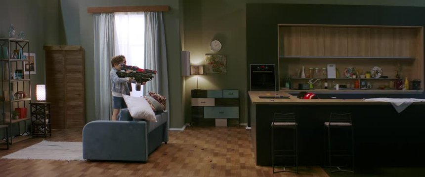 WIDE Kids having a toy gunfight with their father at home. Family having fun during quarantine, playing together. Shot with anamorphic lens