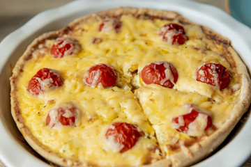 Homemade quiche lorraine with chicken, tomatoes and cheese. French cuisine. Selective focus. Top view. Copy space