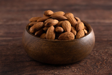 Bowl Full of Raw Natural Almonds on a Dark Wood Table