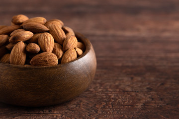 Bowl Full of Raw Natural Almonds on a Dark Wood Table