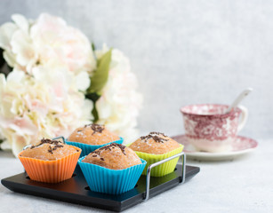 handmade muffins with chocolate shavings and a cup of coffee. Colorful wrappers.