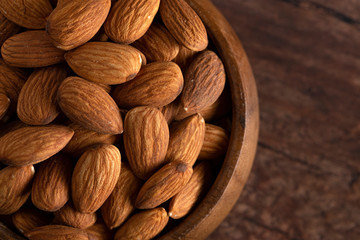 Bowl Full of Raw Natural Almonds on a Dark Wood Table