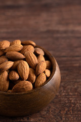 Bowl Full of Raw Natural Almonds on a Dark Wood Table