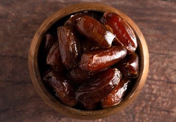 Bowl of Pitted Dates on a Dark Wood Table