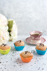 handmade muffins with chocolate shavings and a cup of coffee. Colorful wrappers.
