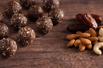Chocolate Energy Protien Balls Made of Raw Organic Nuts and Dates on a Wooden table
