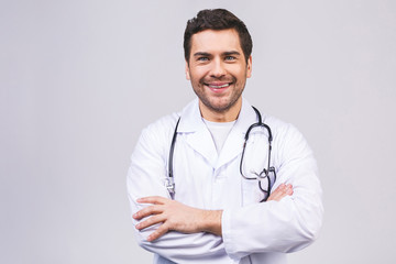 Fototapeta premium Portrait with copy space of cheerful joyful doctor in white lab coat and stethoscope on his neck, having his arms crossed, looking at camera, isolated on white background.