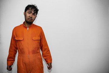 Prisoner in orange robe concept,Portrait of asian handsome man in Prison uniforms,Bandit has a lot of muscle,
