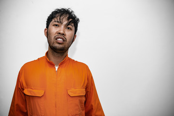 Prisoner in orange robe concept,Portrait of asian handsome man in Prison uniforms,Bandit has a lot...