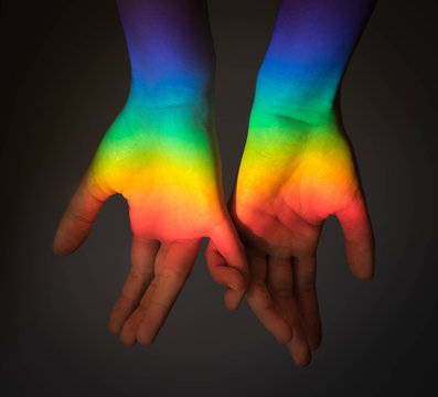 Two person holding hands, patterned as the LGBT rainbow flag. Gay pride concept. Lesbian love concept