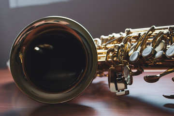 Closeup of saxophone on a wood surface.