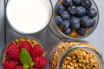 muesli dessert with yogurt and blueberry in a glass on wooden table background. Granola in glass with berries and yogurt on cutting board. breakfast in country style.