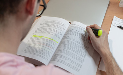 Naklejka premium Teenage boy studies and works at desk in his bedroom