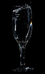 Splashes and drops of water in a glass are isolated on a black .