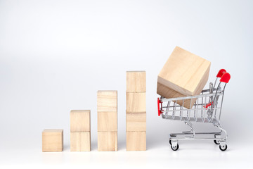 Graphs chart wooden cube block and trolley cart on a white background. Shopping, sale, finance, and...