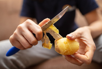 Girl peeling boiled potatoes with a knife