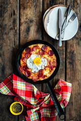 Sourdough breakfast skillet pizza with fried egg, pepperoni and mozzarella cheese