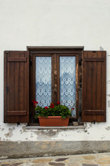 Old window with shutters and a flower pot.