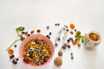 Healthy breakfast - organic granola with honey, oatmeal, cashew nut, almond, raisin and strawberries, blueberries on a white background. The concept of diet.copy space.