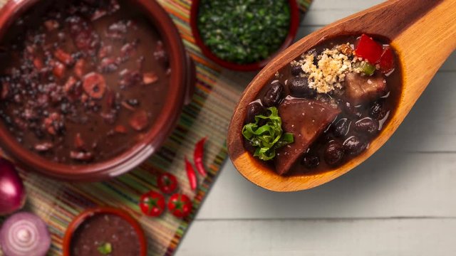 Slide shot Brazilian feijoada on the table with smoke. Top View