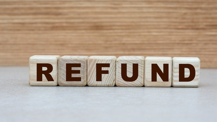 concept of the word REFUND on cubes on a wooden background