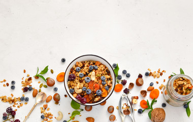 Healthy breakfast - organic granola with honey, oatmeal, cashew nut, almond, raisin and strawberries, blueberries on a white background. The concept of diet.copy space.