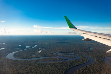 Flying over the Amazonas river, airplane wing.