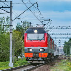 Obraz premium Passenger train moves from the station at evening time..