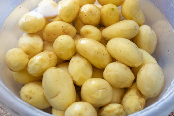 lots of fresh peeled whole potatoes in a bowl of water