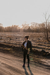 Young girl walking on a dirt road in nature. A young woman in a leather jacket in nature