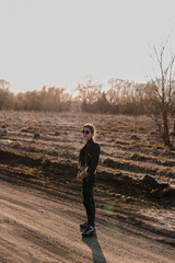 Young girl walking on a dirt road in nature. A young woman in a leather jacket in nature