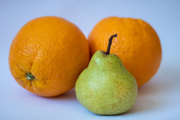 Two oranges and one pear on a white isolated background