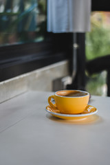 Yellow cup of coffee on table