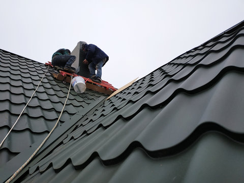 Working with roofing material, metal roof, hand tools screwdriver.