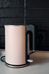 Boiling modern electric kettle. Minimalist interior design. Stylish kitchen. Black brick wall in a designer minimalist room interior of an architect.