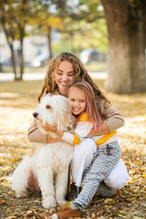 Beautiful, happy young mother with little girl and dog outdoor.