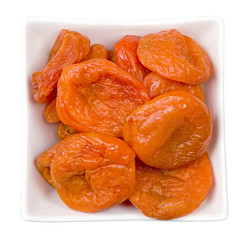 Isolated dried apricots. Bowl of dried apricots isolated on white background with clipping path. Top view.