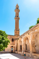 Young girl walking inside of ancient mosque yard in the city of Mardin