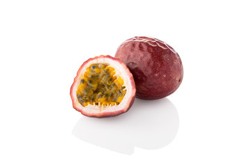Sliced passion fruit - Single half one whole passion fruit facing left on a white background.