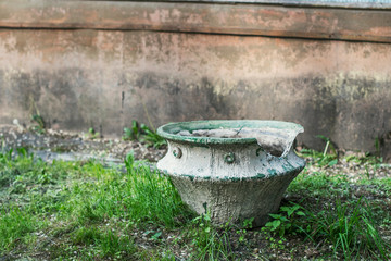 An old broken flower pot in a city Park on a summer day.