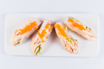 Rolls of rice paper with vegetables and seafood on white background isolated. Traditional Japanese cuisine