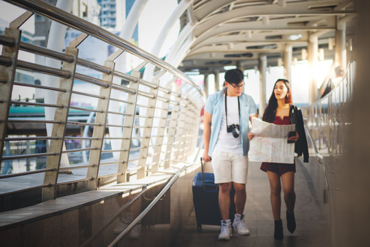 Blurred soft images of Asian tourist couple Walking on the ramp of the train station and are helping to see the map Combined with tourism planing, concept to people travel on vacation and summer
