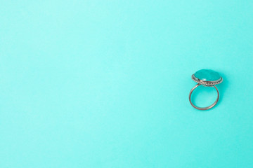 Ring with blue stone on a blue background with copyspace