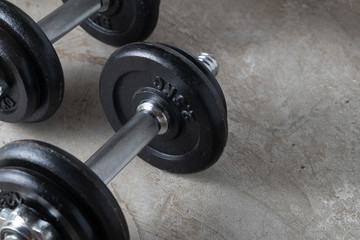 Dumbbells for muscle building exercise placed on cement floor with copyspace.Body workout in the gym training concept.new normal popular lifestyles for strong and healthy bodybuilding at home