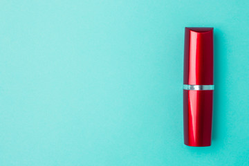 Red lipstick on a blue background with copyspace.