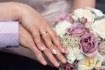 Obraz na płótnie Canvas Justwedding couple hands with rings on bridal bouquet background
