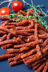 meat snacks on a dish with rosemary and tomatoes