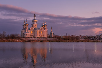 Sokilnyky, Lviv, Ukraine, Pustomyty district. Lake and church at sunset. April 2020