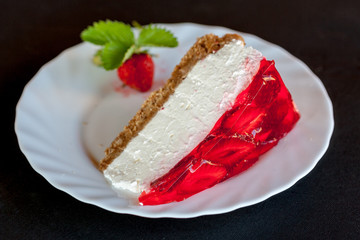 Strawberry cheesecake with fresh strawberries perfectly arranged on a white plate