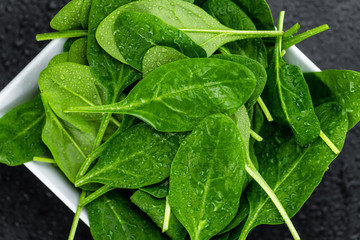 Fresh Spinach on a dark slate slab (close-up shot)